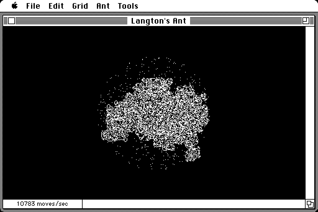 A screenshot of Langton’s ant running on a monochrome Macintosh. The ant is working within a circle of randomly placed dots. It is generating chaotic patterns inside the circle, but will eventually form a highway and escape.